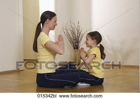 mother and daughter sitting face to face on floor doing yoga together View Large Photo Image Stock Image - mother and daughter sitting face to face on floor doing yoga together. Fotosearch