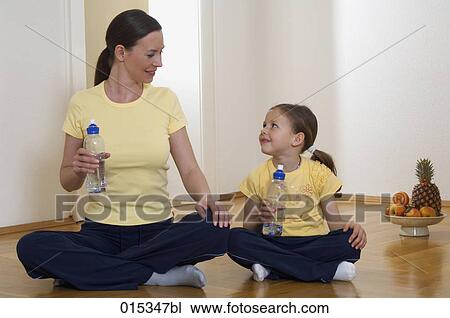 mother and daughter sitting on floor with water bottles looking at each other View Large Photo Image Stock Image - mother and daughter sitting on floor with water bottles looking at each other. Fotosearch