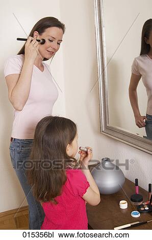 mother and daughter standing in front of mirror applying make-up together View Large Photo Image Stock Image - mother and daughter standing in front of mirror applying make-up together. Fotosearch