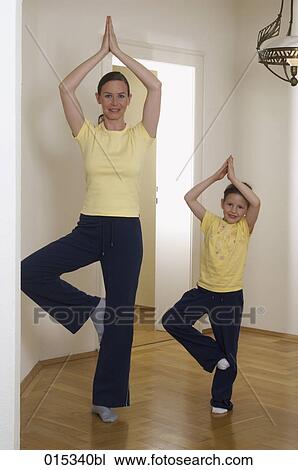 mother and little daughter doing youga tree pose together at home View Large Photo Image Stock Image - mother and little daughter doing youga tree pose together at home. Fotosearch