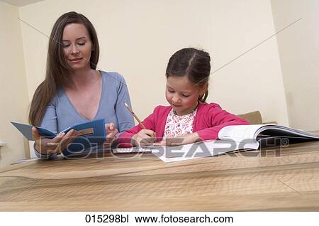 mother checking book while young daughter is doing her homework View Large Photo Image Stock Image - mother checking book while young daughter is doing her homework. Fotosearch