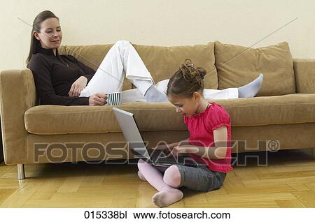 mother lying on sofa watching her little daughter typing on computer View Large Photo Image Stock Image - mother lying on sofa watching her little daughter typing on computer. Fotosearch