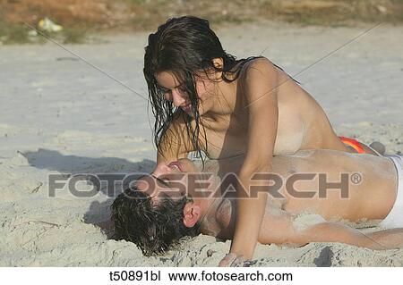 Stock Image - Playful couple on the beach. Fotosearch