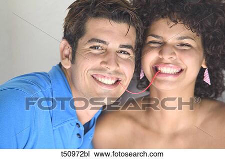 Stock Image - Portrait of a playful couple with gum. Fotosearch