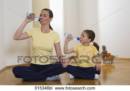 portrait of mother and daughter sitting on floor drink water from plastic bottles View Large Photo Image Stock Image - portrait of mother and daughter sitting on floor drink water from plastic bottles. Fotosearch