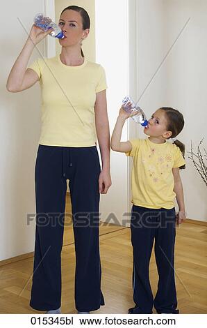 portrait of mother and little daughter drinking water from plastic bottles View Large Photo Image Stock Image - portrait of mother and little daughter drinking water from plastic bottles. Fotosearch