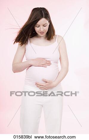 portrait of pregnant young woman looking down on her belly View Large Photo Image Stock Image - portrait of pregnant young woman looking down on her belly. Fotosearch