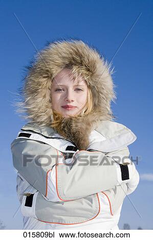 Stock Image - portrait of teenage girl protecting herself from winter coldness. Fotosearch