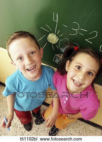 Portrait of two a boy and girl in front of blackboard View Large Photo Image Stock Image - Portrait of two a boy and girl in front of blackboard. Fotosearch