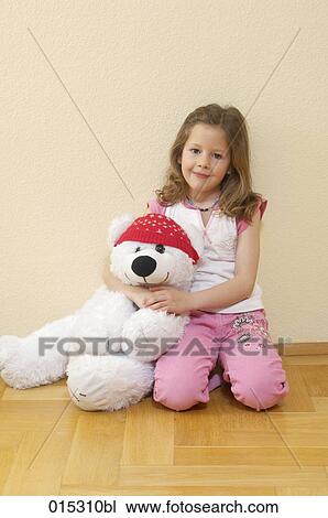 portrait of young kneeling on floor holding cuddly toy in shape of polar bear View Large Photo Image Stock Image - portrait of young kneeling on floor holding cuddly toy in shape of polar bear. Fotosearch