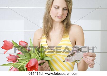 portrait of young woman holding bunch of tulips and reading love letter View Large Photo Image Stock Image - portrait of young woman holding bunch of tulips and reading love letter. Fotosearch
