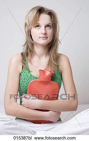 portrait of young woman in bed holding hot water bottle View Large Photo Image Stock Image - portrait of young woman in bed holding hot water bottle. Fotosearch