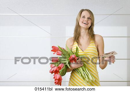 portrait of young woman in yellow summer dress holding bunch of tulips and love letter View Large Photo Image Stock Image - portrait of young woman in yellow summer dress holding bunch of tulips and love letter. Fotosearch