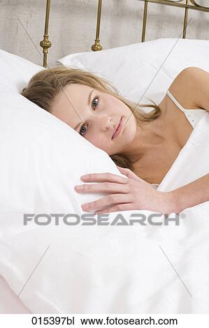 portrait of young woman lying in bed View Large Photo Image Stock Image - portrait of young woman lying in bed. Fotosearch