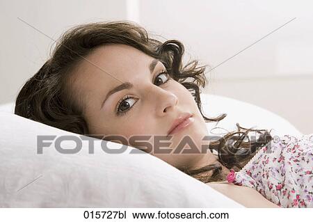portrait of young woman lying in bed View Large Photo Image Stock Image - portrait of young woman lying in bed. Fotosearch