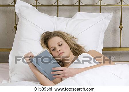 portrait of young woman reading book in bed View Large Photo Image Stock Image - portrait of young woman reading book in bed. Fotosearch