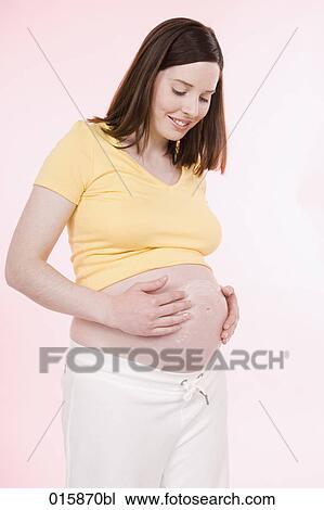 pregnant young woman applying lotion on her belly to avoid stretch marks View Large Photo Image Stock Image - pregnant young woman applying lotion on her belly to avoid stretch marks. Fotosearch