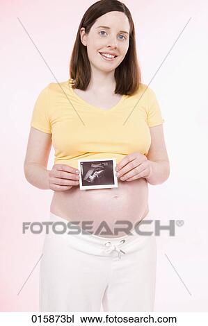 pregnant young woman holding ultrasound photograph of fetus View Large Photo Image Stock Image - pregnant young woman holding ultrasound photograph of fetus. Fotosearch