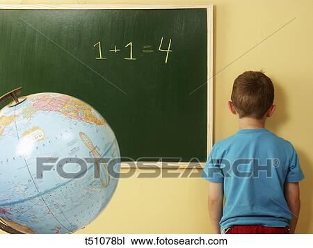 Rear view of a boy in classroom standing by blackboard View Large Photo Image Stock Image - Rear view of a boy in classroom standing by blackboard. Fotosearch