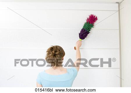 rear view of young woman dusting curtains View Large Photo Image Stock Image - rear view of young woman dusting curtains. Fotosearch
