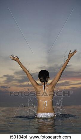 Rear view woman of a woman at sea standing in shallo water View Large Photo Image Stock Image - Rear view woman of a woman at sea standing in shallo water. Fotosearch