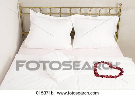 red flower wreath in shape of heart lying on bed View Large Photo Image Stock Image - red flower wreath in shape of heart lying on bed. Fotosearch