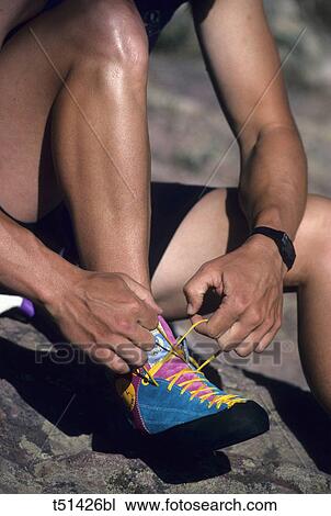 Rock climber lacing up shoes View Large Photo Image Stock Image - Rock climber lacing up shoes. Fotosearch
