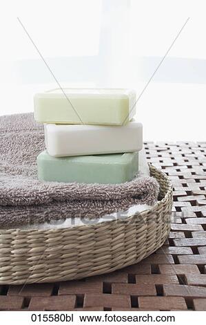 Stock Image - still life of basket towels and three pieces of soap. Fotosearch