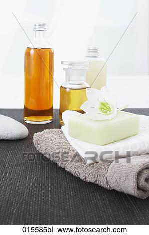 Stock Image - still life of cosmetic bottles towels soap and flower. Fotosearch