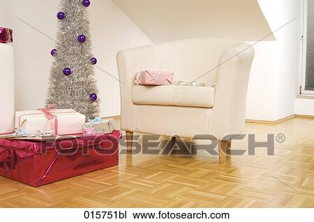 Stock Image - still life with arm chair christmas tree and presents. Fotosearch