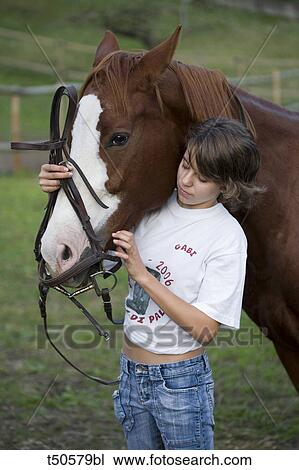 Teenage girl adjusting horse's bridle View Large Photo Image Stock Image - Teenage girl adjusting horse's bridle. Fotosearch