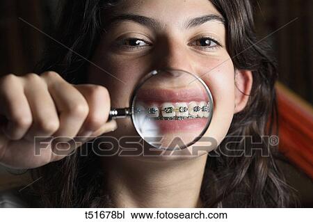 Stock Image - Teenage girl with lens on her mouth. Fotosearch