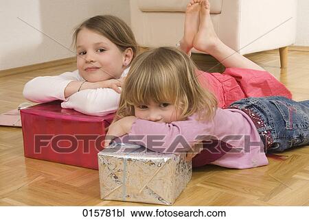 two sisters lying on floor with christmas presents View Large Photo Image Stock Image - two sisters lying on floor with christmas presents. Fotosearch