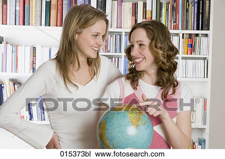 two teenage girls standing around globe smiling at each other View Large Photo Image Stock Image - two teenage girls standing around globe smiling at each other. Fotosearch