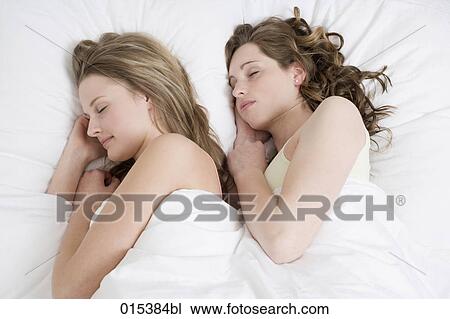 two young women sleeping together in bed View Large Photo Image Stock Image - two young women sleeping together in bed. Fotosearch