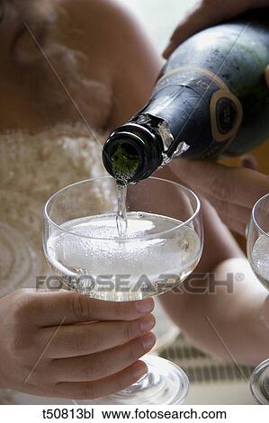 Wedding: pouring champagne on glass View Large Photo Image Stock Image - Wedding: pouring champagne on glass. Fotosearch
