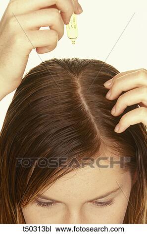 Stock Image - Woman applying hair treatment. Fotosearch