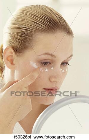 Stock Image - Woman applying moisturizer. Fotosearch