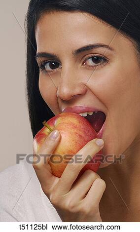 Woman biting a red apple View Large Photo Image Stock Image - Woman biting a red apple. Fotosearch