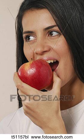 Woman biting a red apple View Large Photo Image Stock Image - Woman biting a red apple. Fotosearch