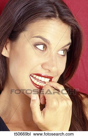 Woman biting her finger View Large Photo Image Stock Image - Woman biting her finger. Fotosearch