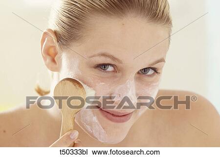 Woman brushing her face View Large Photo Image Stock Image - Woman brushing her face. Fotosearch