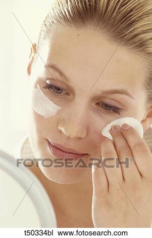 Woman cleaning her face with cotton View Large Photo Image Stock Image - Woman cleaning her face with cotton. Fotosearch