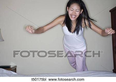 Woman diving onto bed View Large Photo Image Stock Image - Woman diving onto bed. Fotosearch