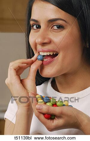Stock Image - Woman eating a candy. Fotosearch