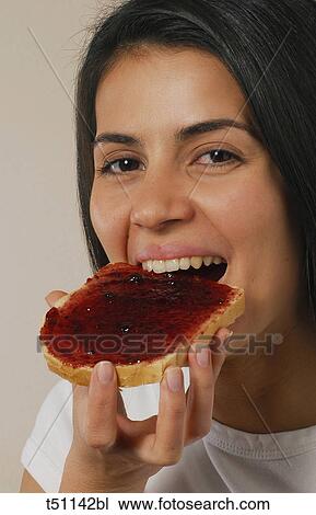 Woman eating a slice of bread with jam View Large Photo Image Stock Image - Woman eating a slice of bread with jam. Fotosearch