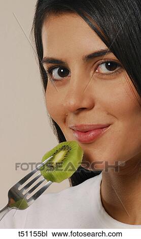 Woman eating a slice of kiwi View Large Photo Image Stock Image - Woman eating a slice of kiwi. Fotosearch