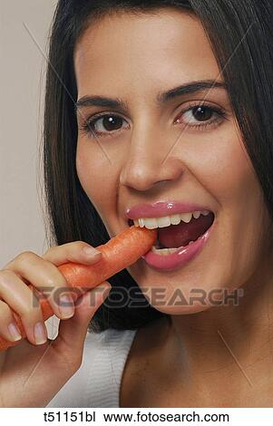 Stock Image - Woman eating carrot. Fotosearch