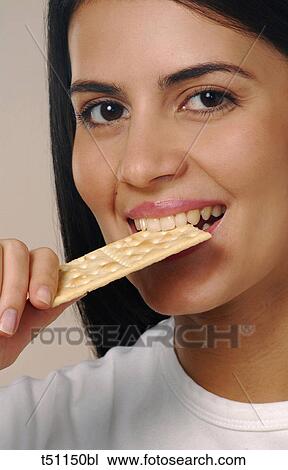 Stock Image - Woman eating cracker. Fotosearch