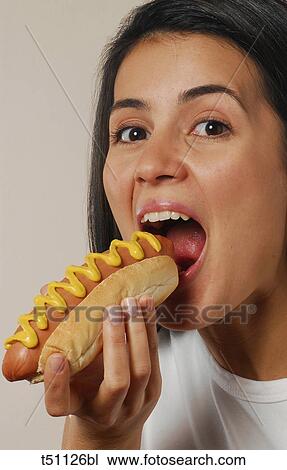 Woman eating hot dog View Large Photo Image Stock Image - Woman eating hot dog. Fotosearch